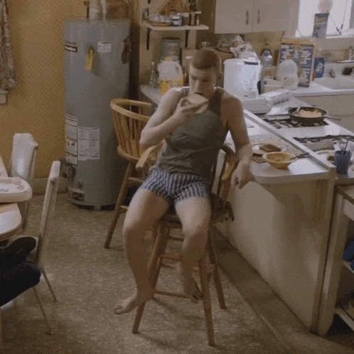 a man sits in a chair in front of a water heater with a sticker on it that says ' johnson '