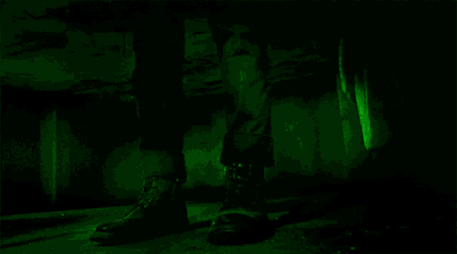 a person 's legs are visible in a dark room with green lights .