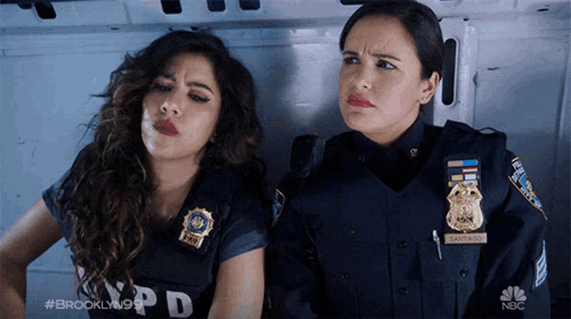 two female police officers sitting next to each other in a van with the letters nbc on the bottom