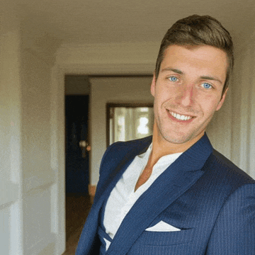 a man in a blue suit and white shirt smiles at the camera