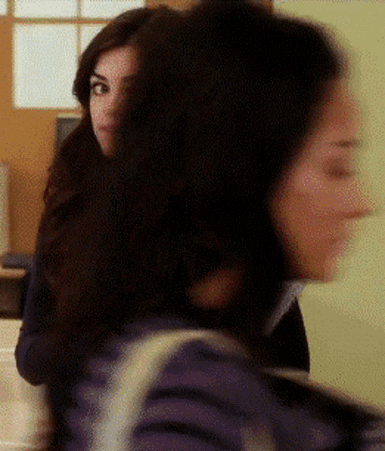 a blurry picture of two women standing next to each other in a room