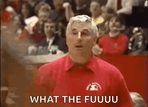 a man in a red shirt is standing in front of a crowd and talking to them .