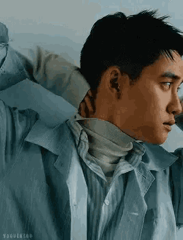 a close up of a man wearing a turtleneck sweater and a blue shirt .