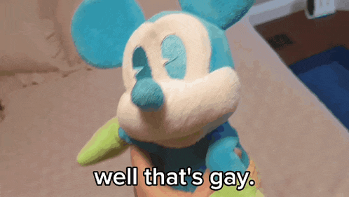 a person is holding a stuffed mickey mouse with the words well that 's gay below it