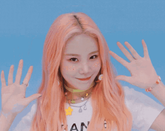 a girl with pink hair is wearing a white shirt that says " an " on it