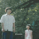 a man and a girl are standing under a tree looking up