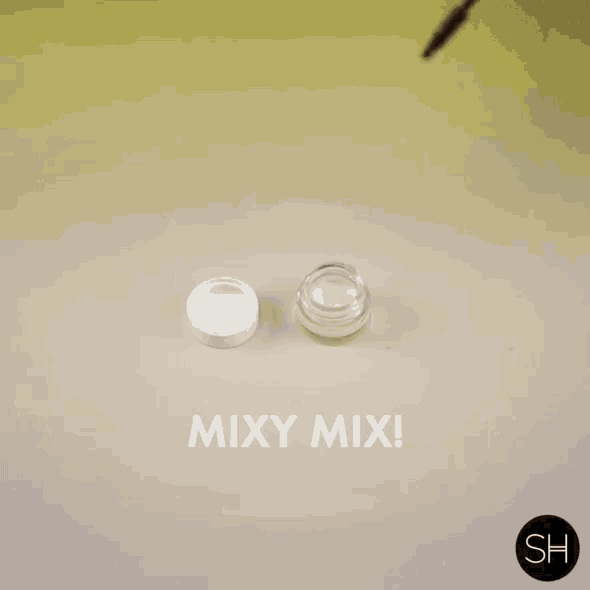 a woman is applying mascara to a small container with the words mixy mix written on the bottom