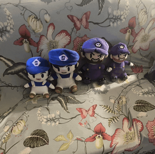 a group of stuffed mario characters are sitting on a couch