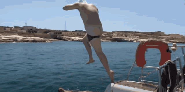 a man jumping into the water from a boat