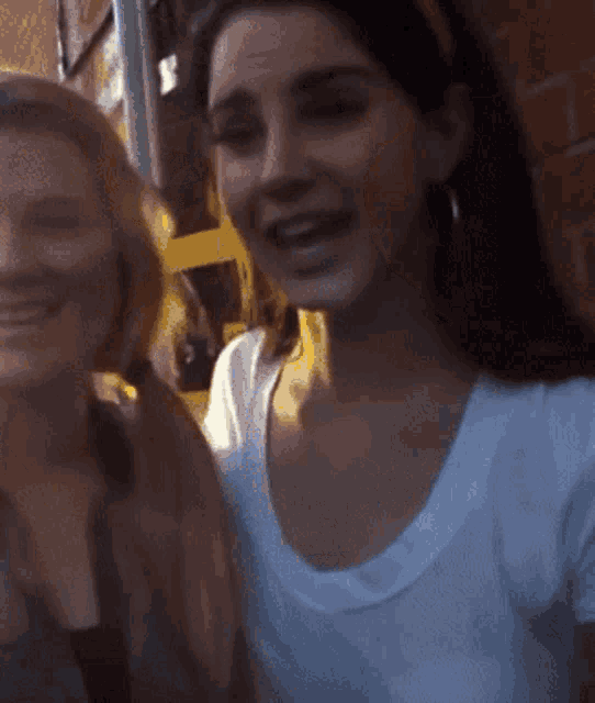 two women are posing for a picture and smiling for the camera