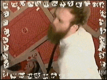 a man with a beard is playing a game of cards with the number 5 on the table