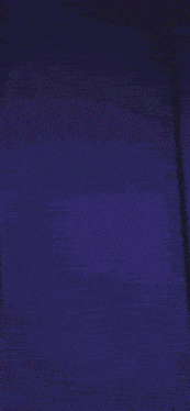 a person is standing in a dark room with a purple light behind them .
