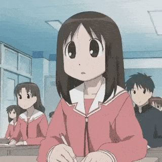 a girl in a pink uniform is sitting at a desk in a classroom