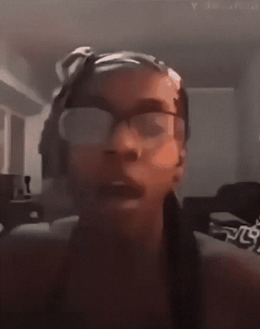 a close up of a person wearing glasses and headphones with the letter p visible