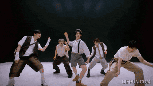 a group of men are dancing in front of a black background with gifrun.com written on the bottom