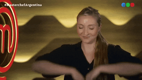 a woman in front of a masterchef argentina logo