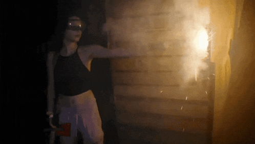 a woman is holding an axe in front of a brick wall