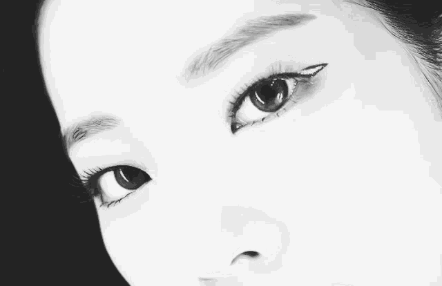 a close up of a woman 's face with a black background
