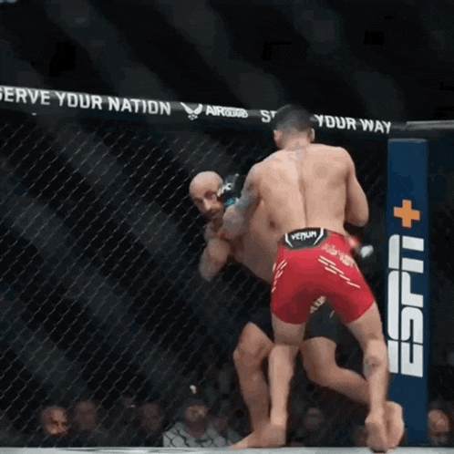 two men are fighting in a cage with a sign that says espn