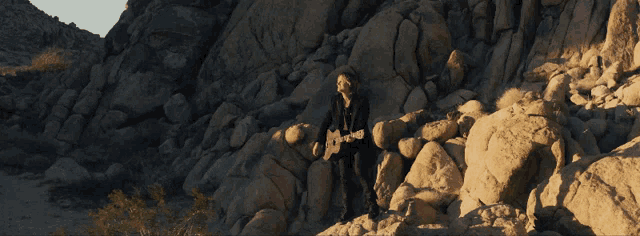 a man standing on a rocky cliff looking down