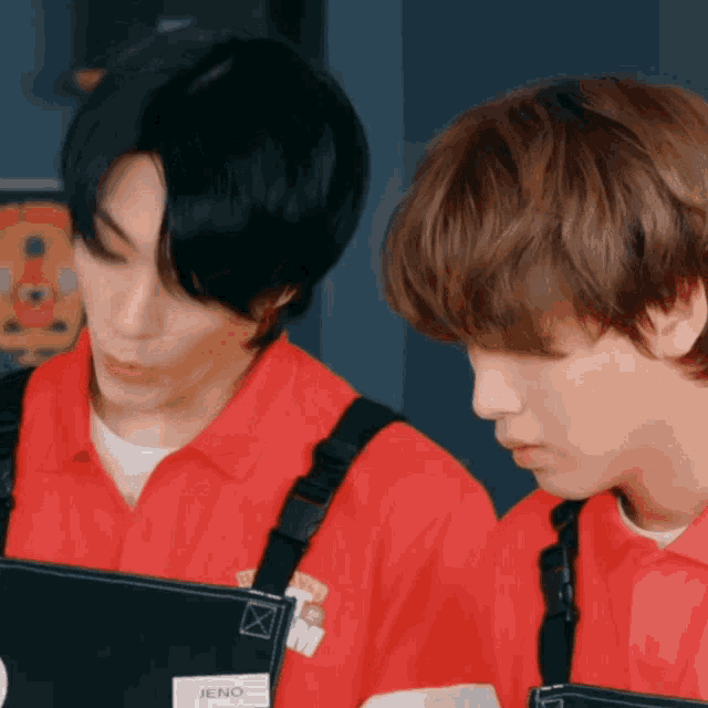 two men wearing red shirts with the name jeno on the front