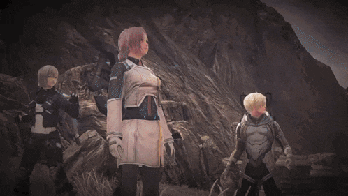 a group of people are standing on a dirt road with a mountain in the background