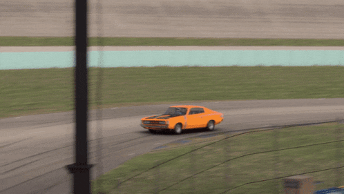 an orange car is driving on a track