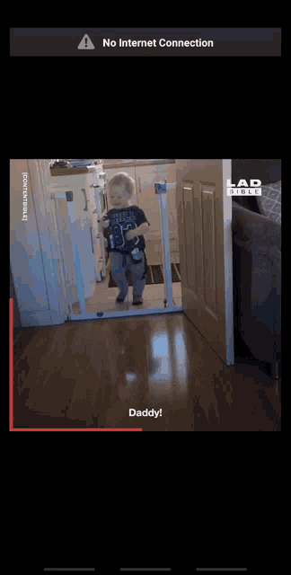 a screen shot of a baby behind a gate with the words daddy on the bottom