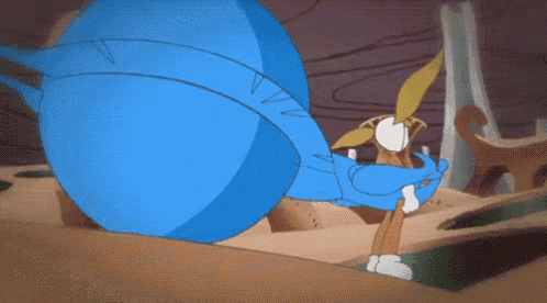 a blue cartoon character is standing in a desert holding a stick