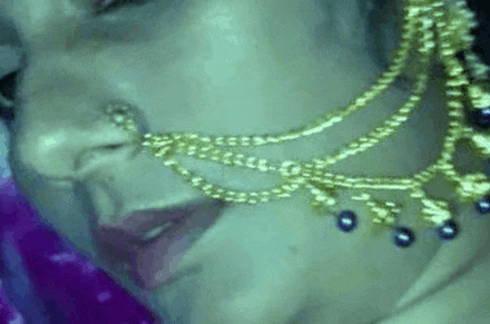 a woman is wearing a nose ring and a necklace .