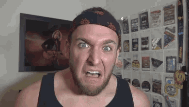 a man with a beard wearing a bandana is making a funny face .