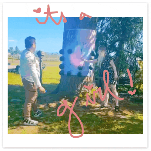 a man and a woman are standing in front of a tree with the words it 's a girl written on the bottom