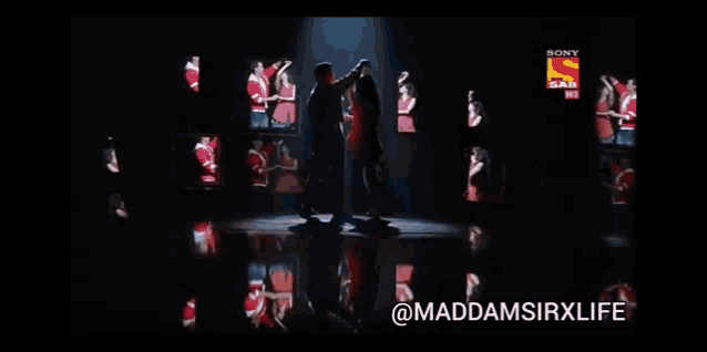 a man and a woman are standing next to each other on a stage with a sony logo in the background .