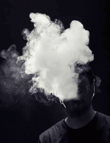 a man is blowing smoke out of his mouth .