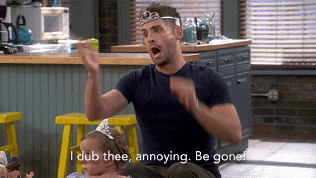 a man with a tiara on his head is holding a baby and says " i dub thee annoying be gone "