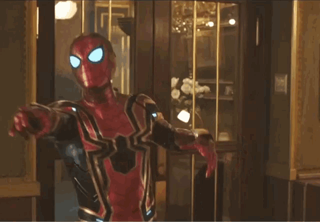 a man in a red and gold spiderman costume is pointing