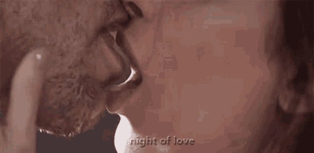 a close up of a man and woman kissing with the words `` night of love '' written above them .
