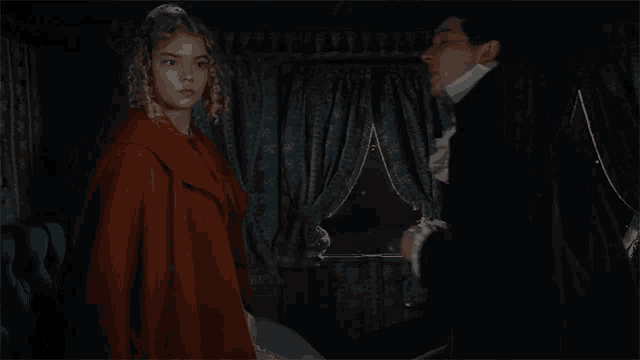 a man and a woman are standing next to each other in a room