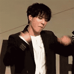 a man in a suit and white shirt is dancing .