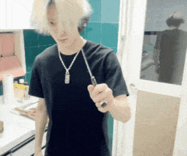a man in a black shirt is holding a screwdriver in his hand
