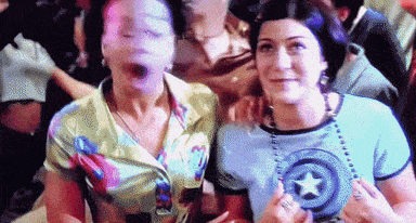 two women are posing for a picture with one wearing a shirt with a star on it .