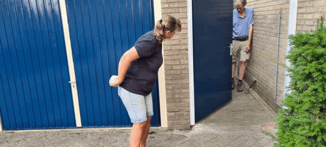 a man and a woman are standing in front of a blue door