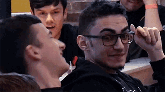 a group of young men are sitting around a table in a restaurant .