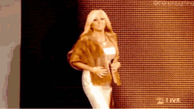 a woman is standing in front of a wall that says live