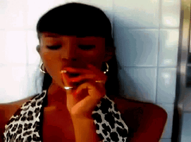 a woman in a leopard print top is smoking