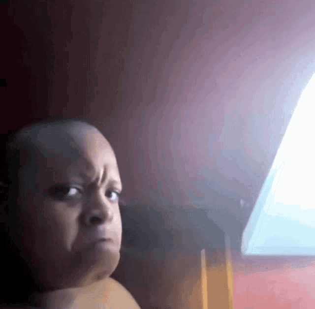 a shirtless baby making a funny face in front of a lamp