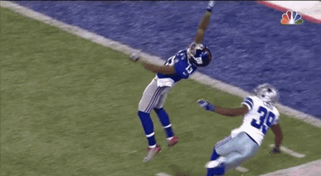a football player with the number 39 on his back is trying to catch the ball