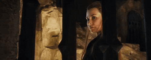 a woman is standing in front of a window in a dark room .