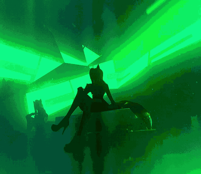 a silhouette of a woman sitting in front of a green background