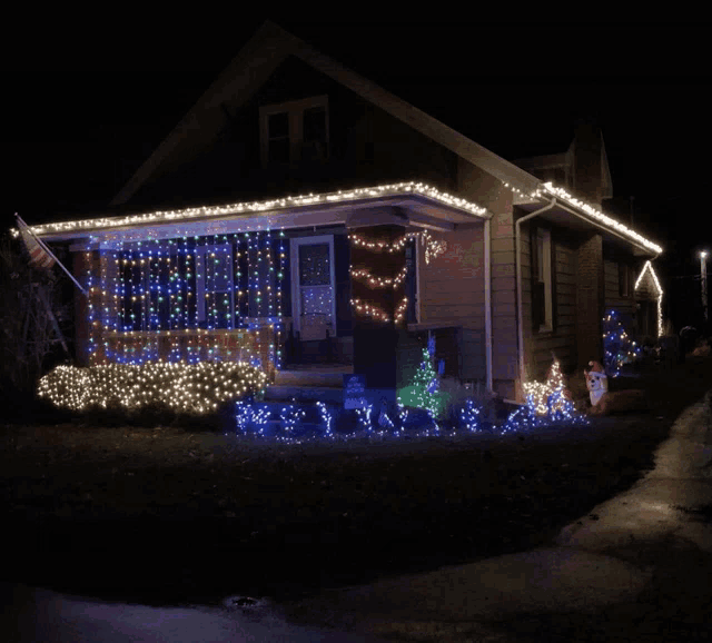 a house is decorated with christmas lights and a flag